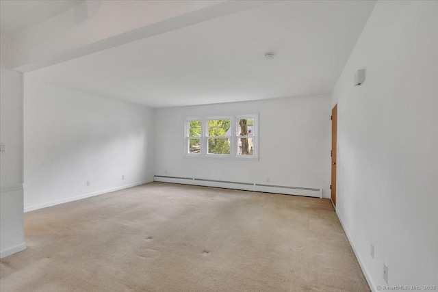 carpeted spare room with a baseboard radiator and baseboards