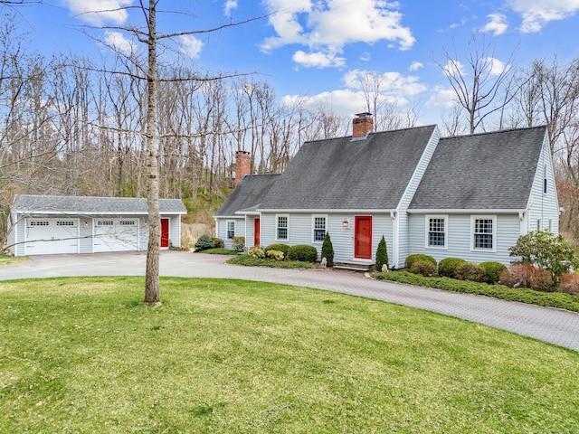 cape cod home with a chimney, a shingled roof, an outbuilding, a garage, and a front lawn