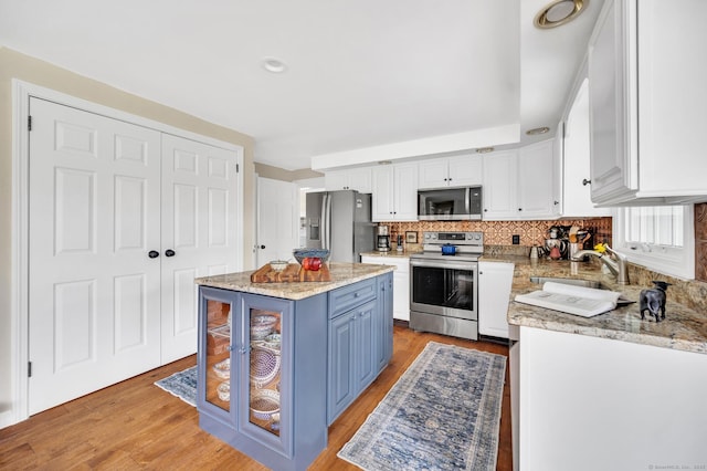 26 Old Kentwood Rd, East Haddam, CT 06423 - kitchen featuring stainless steel appliances, a sink, white cabinets, blue cabinets, and tasteful backsplash