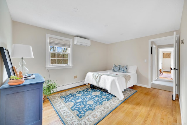 bedroom featuring wood finished floors, an AC wall unit, a baseboard heating unit, and baseboards