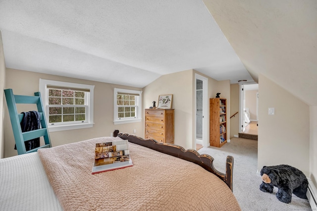 bedroom with a textured ceiling, carpet flooring, and vaulted ceiling