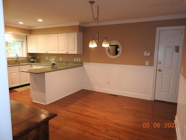 70 Allison Way Unit 70, East Haven, CT 06512 - kitchen featuring a sink, a wainscoted wall, white cabinets, dark wood-style floors, and a peninsula