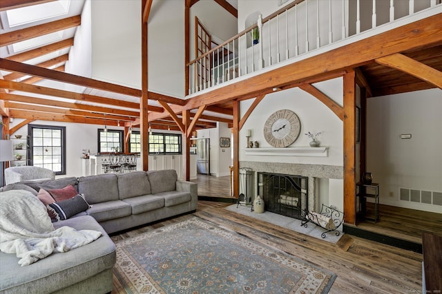 128 Spaulding Rd, Brooklyn, CT 06234 - living area with wood finished floors, a fireplace with flush hearth, beam ceiling, a skylight, and high vaulted ceiling