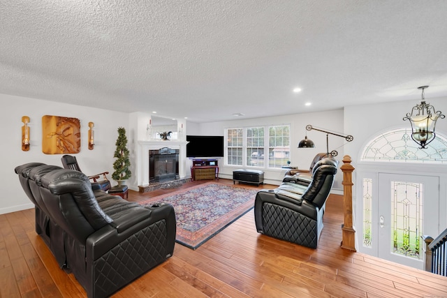 340 Brookfield St, South Windsor, CT 06074 - living area with wood finished floors, a textured ceiling, recessed lighting, a glass covered fireplace, and baseboards