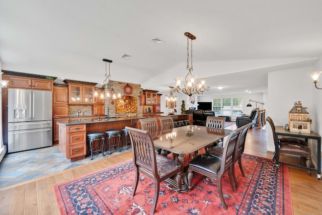 340 Brookfield St, South Windsor, CT 06074 - dining room featuring a chandelier, light wood-style flooring, and vaulted ceiling