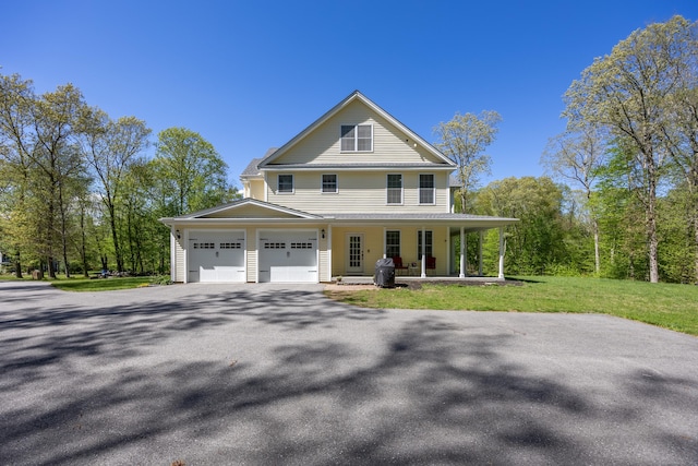 31 Cambridge Ct, Colchester, CT 06415 - view of front of home featuring covered porch, driveway, an attached garage, and a front lawn