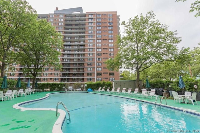 view of swimming pool with fence and a patio