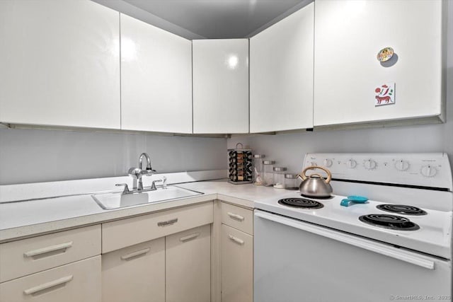 kitchen featuring a sink, light countertops, white cabinetry, and electric stove