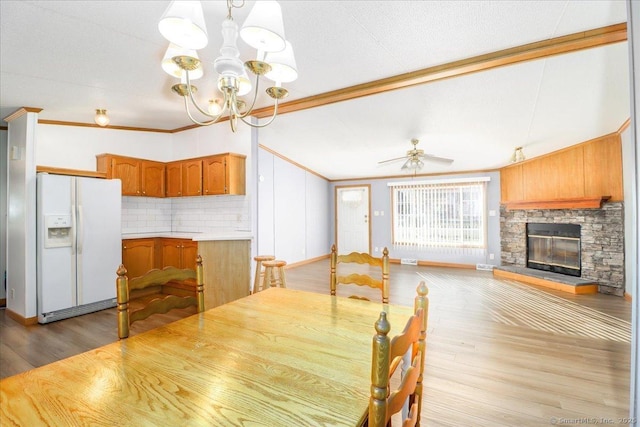 54 Western Sands Sands, Wallingford, CT 06492 - dining room with ceiling fan with notable chandelier, a fireplace, ornamental molding, wood finished floors, and lofted ceiling
