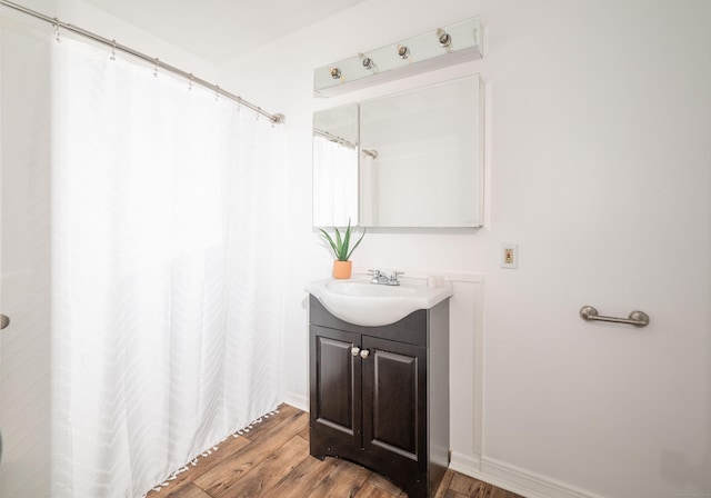 full bath with wood finished floors, vanity, baseboards, and a shower with curtain