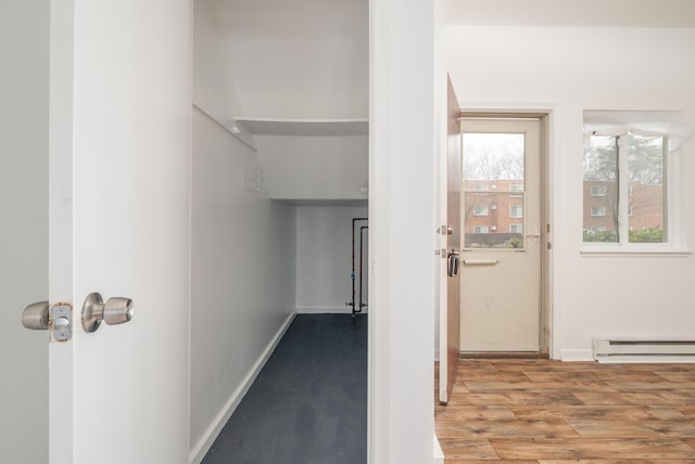 interior space with baseboards, wood finished floors, and baseboard heating