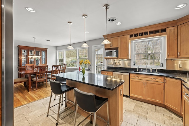 181 Picketts Ridge Rd, Redding, CT 06896 - kitchen with appliances with stainless steel finishes, a sink, decorative light fixtures, a breakfast bar, and recessed lighting