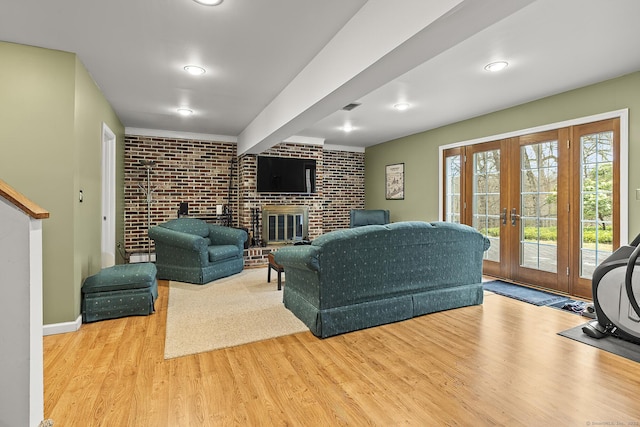181 Picketts Ridge Rd, Redding, CT 06896 - living room with wood finished floors, brick wall, french doors, a fireplace, and baseboards