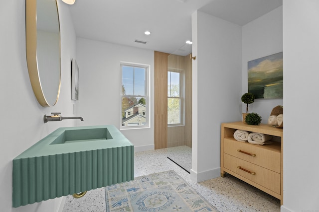 full bath with speckled floor, visible vents, baseboards, and a walk in shower