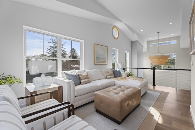 living room with wood finished floors, high vaulted ceiling, and recessed lighting
