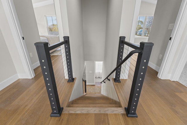 staircase with baseboards and wood finished floors