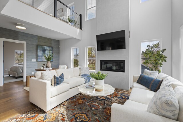 living room with wood finished floors, a high ceiling, and a wealth of natural light
