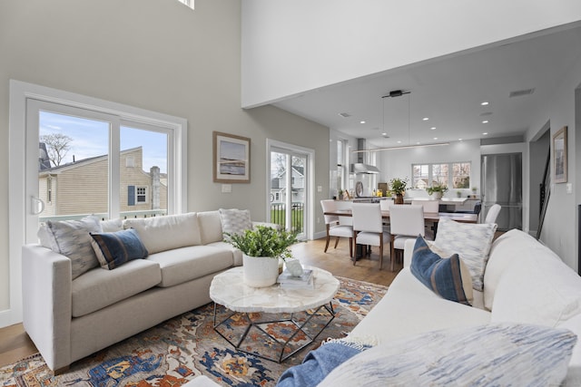 living room featuring baseboards, wood finished floors, visible vents, and recessed lighting