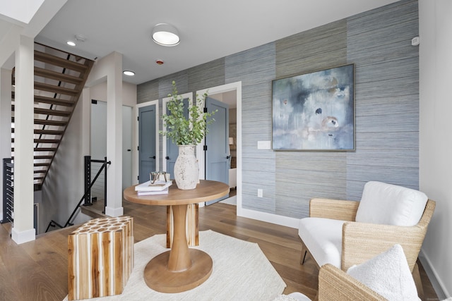 entrance foyer with recessed lighting, stairway, wood finished floors, an accent wall, and baseboards