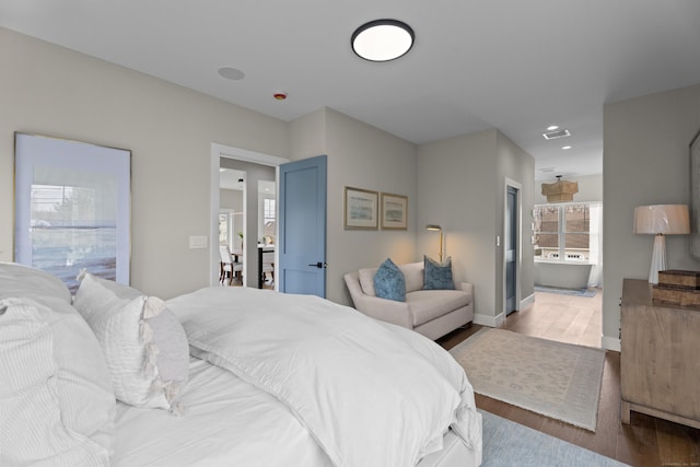 bedroom with wood finished floors, connected bathroom, baseboards, visible vents, and recessed lighting