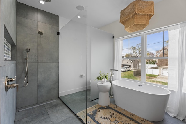 full bathroom featuring tile patterned flooring, walk in shower, and a freestanding tub