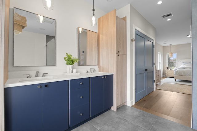 full bathroom featuring double vanity, visible vents, ensuite bathroom, and a sink