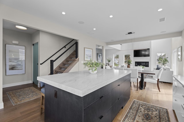 kitchen with dark cabinets, light wood-style flooring, a large island, and modern cabinets