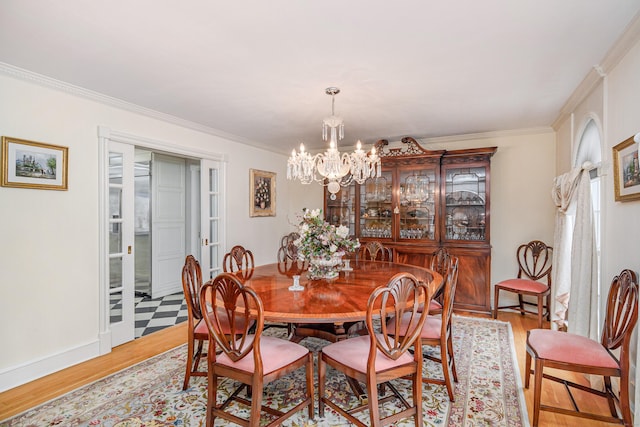 dining area featuring light wood-style floors, crown molding, and a chandelier