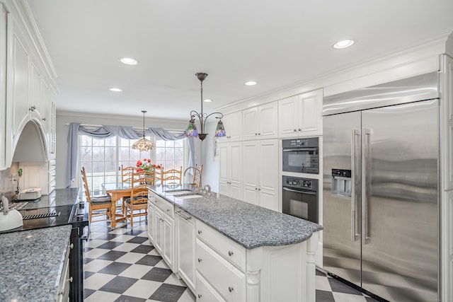 kitchen featuring white cabinets, a sink, a kitchen island with sink, dark floors, and built in fridge