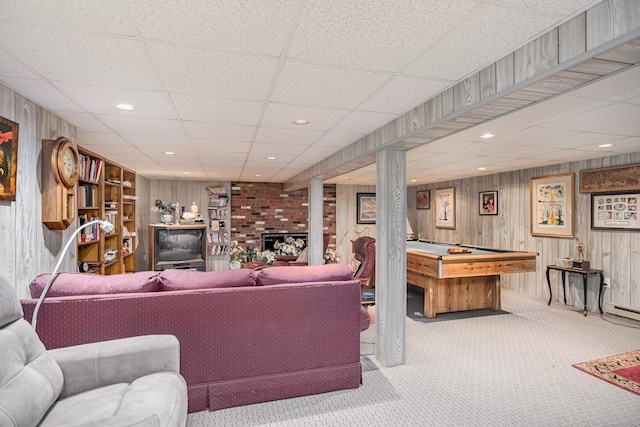 living area featuring carpet flooring, pool table, wood walls, and a drop ceiling