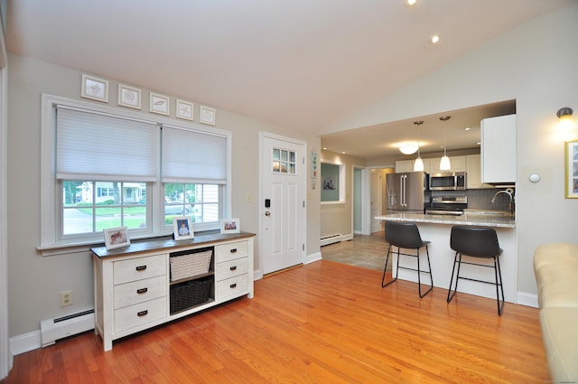 5 Middle Dr, Windsor Locks, CT 06096 - kitchen with stainless steel appliances, a baseboard radiator, a kitchen breakfast bar, white cabinets, and light wood finished floors