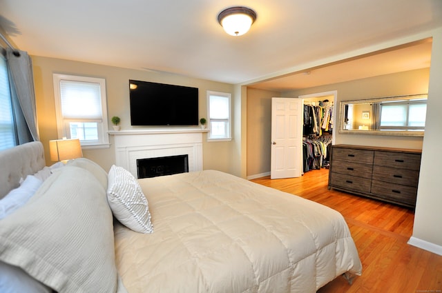 5 Middle Dr, Windsor Locks, CT 06096 - bedroom with light wood-style flooring, a walk in closet, a brick fireplace, and a closet