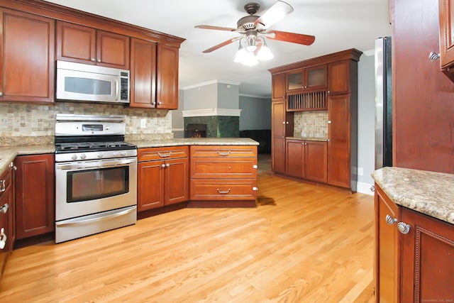 15 Old Stream Ln, Trumbull, CT 06611 - kitchen featuring stainless steel appliances, decorative backsplash, crown molding, ceiling fan, and light wood finished floors