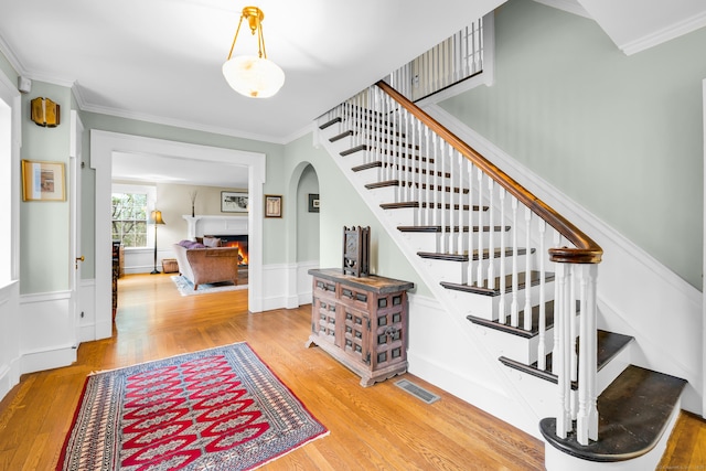 64 Blake Rd, Hamden, CT 06517 - stairs with wood finished floors, crown molding, arched walkways, and wainscoting