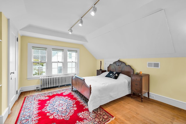 64 Blake Rd, Hamden, CT 06517 - bedroom featuring radiator, wood finished floors, rail lighting, and vaulted ceiling