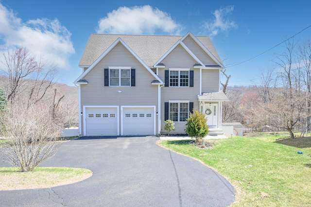 traditional-style home with an attached garage, driveway, roof with shingles, and a front lawn