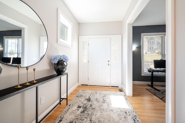 foyer with light wood-style floors and baseboards