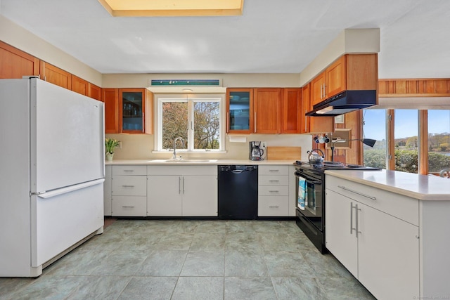 27 Wilbur Rd, Stonington, CT 06378 - kitchen featuring black appliances, a sink, under cabinet range hood, light countertops, and glass insert cabinets