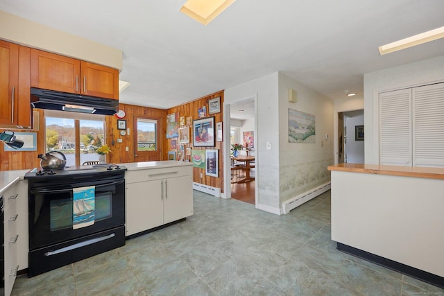 27 Wilbur Rd, Stonington, CT 06378 - kitchen with black range with electric cooktop, under cabinet range hood, a baseboard heating unit, light countertops, and wooden walls