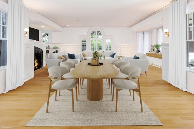 Rogers Is, Branford, CT 06405 - dining space featuring a decorative wall, a lit fireplace, light wood-style floors, and wainscoting