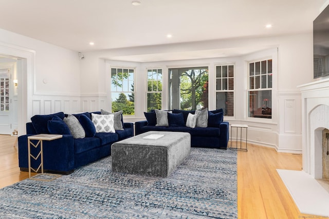 Rogers Is, Branford, CT 06405 - living area with a decorative wall, wood finished floors, wainscoting, recessed lighting, and a fireplace with flush hearth
