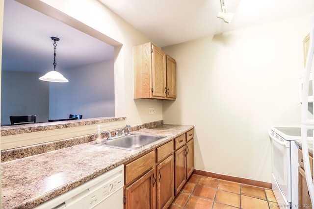 kitchen featuring baseboards, white appliances, light countertops, a sink, and hanging light fixtures