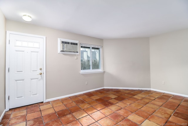 unfurnished room featuring a wall mounted air conditioner and baseboards