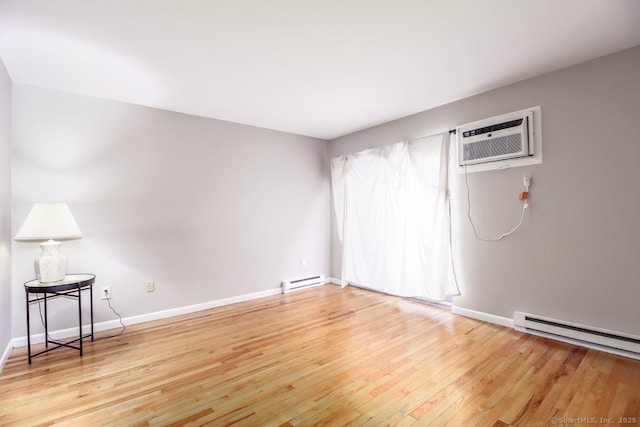 unfurnished room featuring light wood-style floors, baseboards, an AC wall unit, and a baseboard radiator
