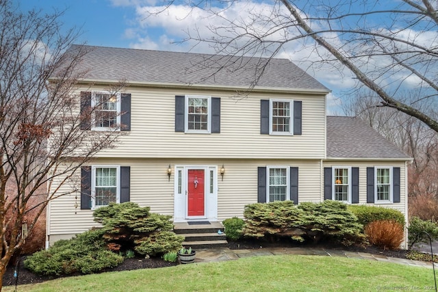 colonial home featuring a shingled roof