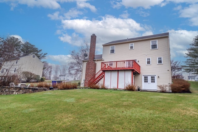 back of house with a chimney, a deck, stairway, and a lawn