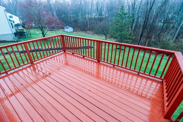 deck featuring a yard, a storage shed, and an outbuilding