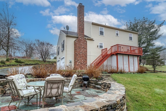 back of property with a patio area, a yard, a chimney, stairway, and a wooden deck