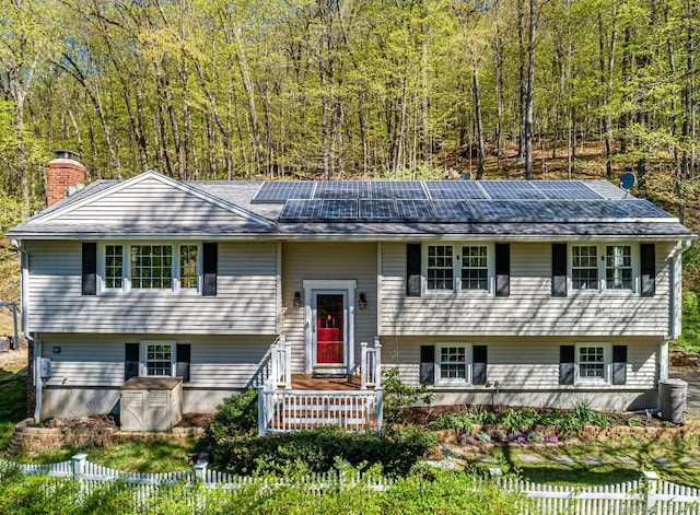 173 Barlow Mountain Rd, Ridgefield, CT 06877 - raised ranch featuring solar panels, a forest view, and a chimney