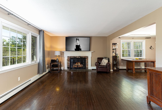 173 Barlow Mountain Rd, Ridgefield, CT 06877 - living room featuring baseboard heating, hardwood / wood-style flooring, a brick fireplace, and plenty of natural light